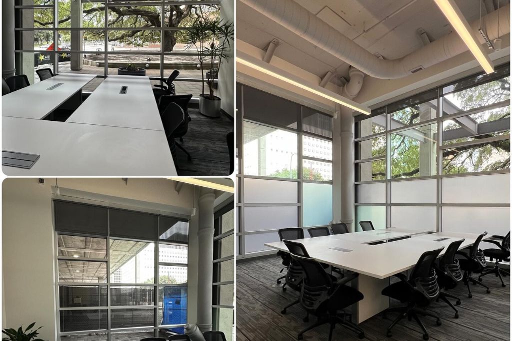 This image features a modern office conference room with large glass windows offering views of the outside. The room is furnished with white desks, black chairs, and overhead lighting. In one section, frosted or tinted windows are used to provide privacy while still allowing natural light. The scene highlights the potential use of window films to balance natural light, privacy, and energy efficiency in an office setting.