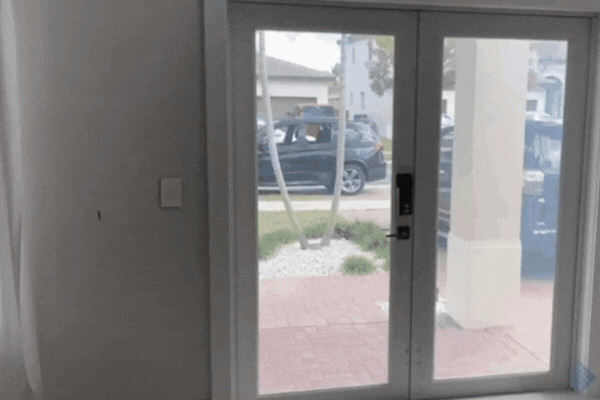 A GIF showing smart window film transitioning from clear to opaque on a set of glass patio doors, demonstrating its ability to block visibility and sunlight with the flip of a switch.