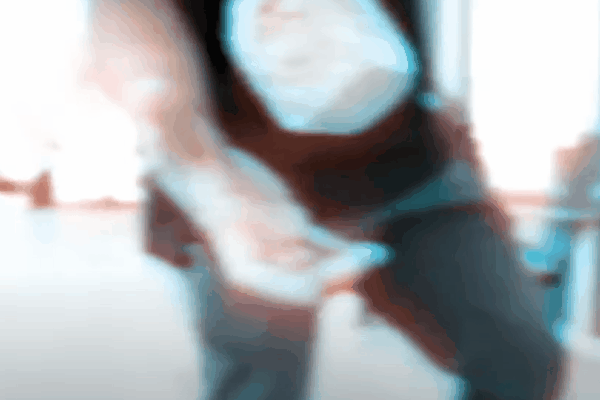 Blurry close-up of a person striking or pressing against glass, illustrating the force that safety and security window film is designed to resist. The motion emphasizes how reinforced glass can slow intruders and reduce injury risks.