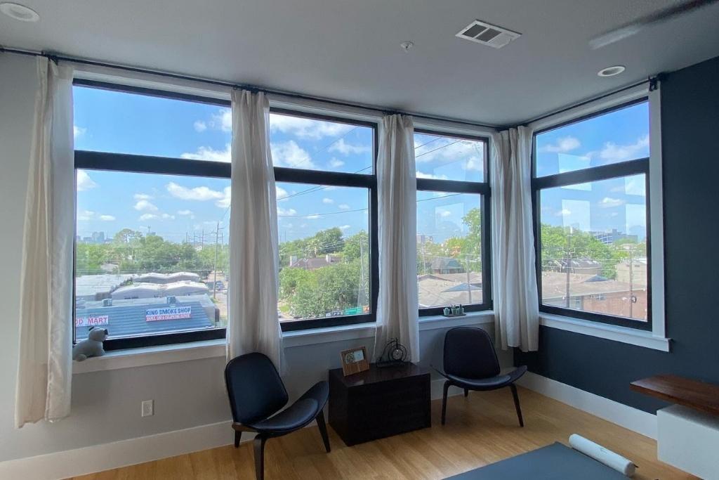 Sunlit residential room with large corner windows professionally tinted by Commercial Film Specialists, offering glare reduction and UV protection.